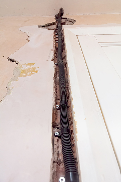 Electric cable conduit attached to wall