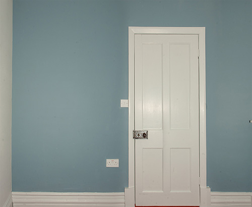 Blue painted wall with white door